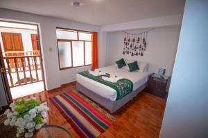 a bedroom with a bed and a balcony at Munay Ñusta Cusco in Cusco