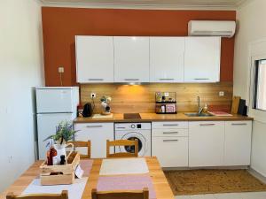 a kitchen with white cabinets and a wooden table at Agrothi in Marathopoli