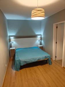 een slaapkamer met een bed en een blauwe muur bij Lagoon House in Santiago do Cacém