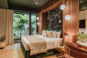 a bedroom with a bed and a table with chairs at Selvario 36 Hotel in Medellín