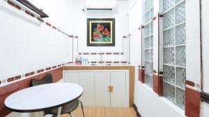 a kitchen with a white table and a sink at RedDoorz at Plus Villa Gloria Taguig in Manila