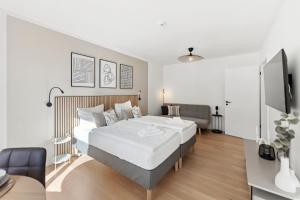 a hotel room with two beds and a couch at kitchenroombed - Top City-Lage I nahe Hbf I bis 5P I Aufzug I Tiefgarage I Terrasse in Halle an der Saale
