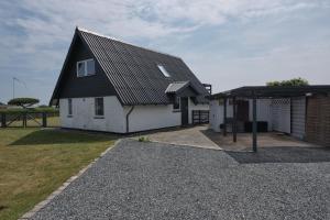 ein kleines weißes Haus mit schwarzem Dach in der Unterkunft Nice Home In Ebeltoft With 4 Bedrooms, Sauna And Wifi in Ebeltoft