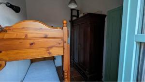ein Schlafzimmer mit einem Holzbett neben einem Holzschrank in der Unterkunft Il Plumbago - Elba Affitti in Mortigliano