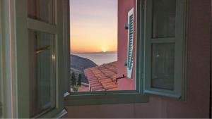 ein offenes Fenster mit Blick auf einen Sonnenuntergang in der Unterkunft Il Plumbago - Elba Affitti in Mortigliano