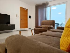 a living room with a couch and a tv at Blue Pearl in Żurrieq