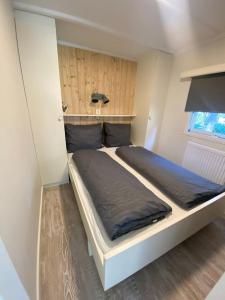 una camera da letto con un letto grande in una stanza di Prachtig Boschalet met CV, Airco en Sauna op de Veluwe a Doornspijk Altre 21 foto