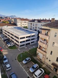 un edificio de apartamentos con coches aparcados en un aparcamiento en Rosemary, en Podgorica