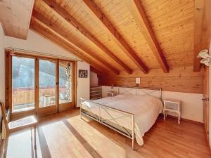 una camera da letto con un letto e un soffitto in legno di L Eau Vive Combles a Le Châble