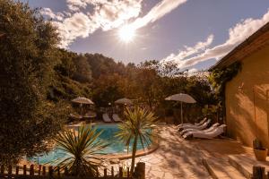 a pool with chairs and umbrellas in a yard at NOUS in Agel