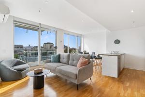 un soggiorno con un divano e un tavolo di Port Melbourne and a glimpse of the sparkling bay - sleeps 4 a Melbourne