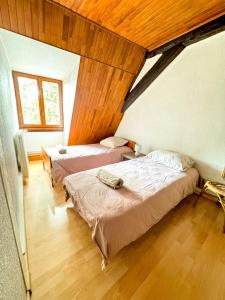 two beds in a room with wooden ceilings at Central & quiet, Full apt for 8 Trésor caché in Colmar