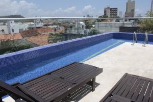 - une piscine au-dessus d'un bâtiment avec un banc dans l'établissement Modern Comfort - Spacious 2BR in Walled City, à Carthagène des Indes