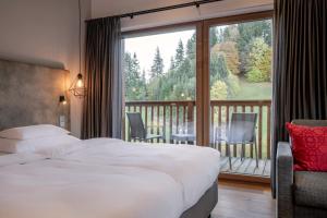 una habitación de hotel con una cama y un balcón en Hotel Der Bär, en Ellmau