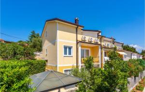 budynek z parasolką przed nim w obiekcie 3 Bedroom Cozy Apartment In Dobrinj w mieście Dobrinj
