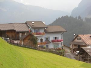 eine Gruppe von Häusern an der Seite eines Hügels in der Unterkunft Casa Tania in Pozza di Fassa