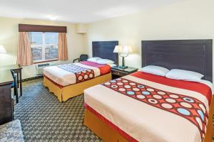a hotel room with two beds and a window at Super 8 by Wyndham Calgary/Airport in Calgary