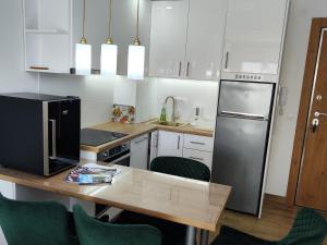 a kitchen with a table with chairs and a refrigerator at Todorovic Apartments Panorama in Kragujevac