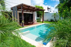 a swimming pool in a yard with a pergola at Elegant and comfortable villa in Real Montejo in Dzitya