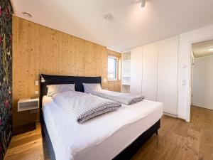 ein Schlafzimmer mit einem großen Bett mit weißer Bettwäsche in der Unterkunft Wolf & Schäfchen in Oberstaufen