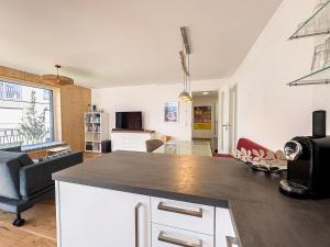 eine Küche und ein Wohnzimmer mit einer Arbeitsplatte in der Unterkunft Wolf & Schäfchen in Oberstaufen