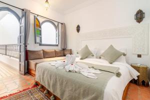a bedroom with two beds and a couch at Riad La Kasbah secrète in Marrakech +40 photos