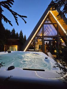 a jacuzzi tub in front of a house at Navas River House in Poljane