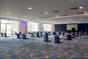 a conference room with tables and chairs and a screen at The Chelsea Harbour Hotel and Spa in London +107 photos