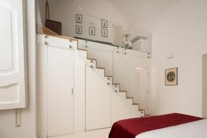 scala bianca in una camera con letto di A.RI.EL luxury apartment a Napoli