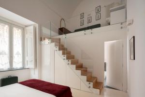 Camera bianca con scala e letto di A.RI.EL luxury apartment a Napoli