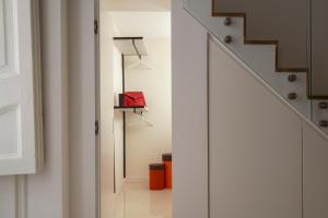 un corridoio con scale e una scatola rossa su uno scaffale di A.RI.EL luxury apartment a Napoli Altre 12 foto