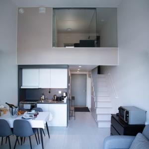 a kitchen and a living room with a table and chairs at Elegant Penthouse Loft - Near the Airport in Vantaa