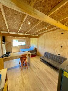a room with a couch and a bed and a table at TinyHouse Box Lican Ray in Licán Ray