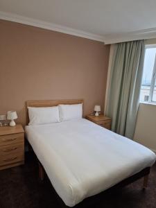 a bedroom with a large white bed and a window at Britannia Hotel Birmingham New Street Station Birmingham in Birmingham