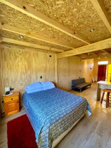 a bedroom with a bed and a couch and a table at TinyHouse Box Lican Ray in Licán Ray