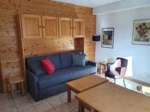 a living room with a blue couch and a table at cellier 1 in Les Deux Alpes
