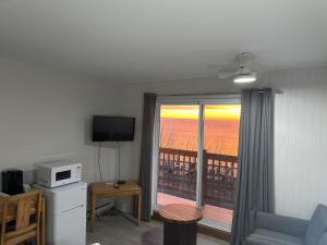 a living room with a view of a balcony at Motel Carleton Sur Mer in Carleton-sur-Mer