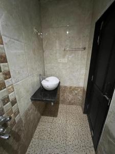 a bathroom with a white toilet on a black counter at Sportsman Beach Hotel in Calangute