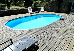a large swimming pool on a wooden deck with a bench at Clipgites in Pleugriffet