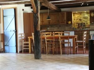 a kitchen with a table and chairs and a refrigerator at Clipgites in Pleugriffet
