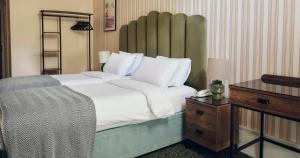 a bedroom with a large bed and a table with a lamp at The Columbia in London +30 photos