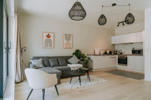 a living room with a couch and a kitchen at 2 bedroom apartment and private parking in Liège center in Liège