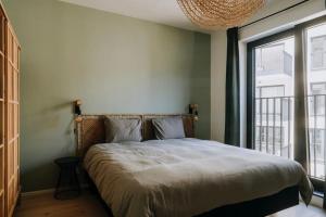 a bedroom with a bed with a large window at 2 bedroom apartment and private parking in Liège center in Liège