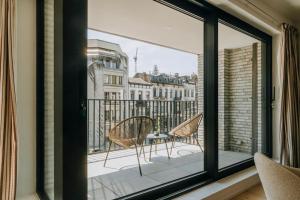 a balcony with two chairs and a table on a balcony at 2 bedroom apartment and private parking in Liège center in Liège