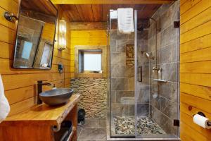 a bathroom with a glass shower with a sink and a sink at The Lodge in Canton +32 photos