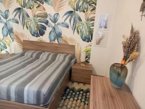 een slaapkamer met een bed en een vaas op een tafel bij Home sweet Home Rita in Lecco
