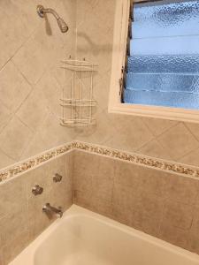 a bathroom with a bath tub and a window at Sunny apartment Vicente Lopez in Vicente López