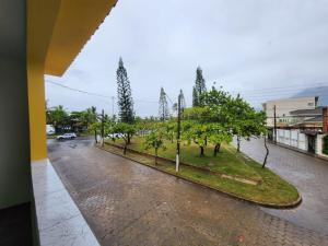 an empty street with trees and a parking lot at Casa Peruibe frente a praia in Peruíbe