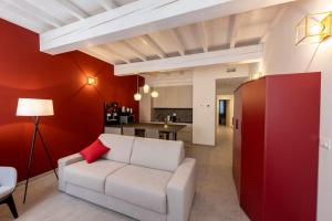 a living room with a white couch and a red wall at Red Suite - City center & Garage in Parma