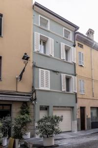 a large white building with windows on a street at Red Suite - City center & Garage in Parma